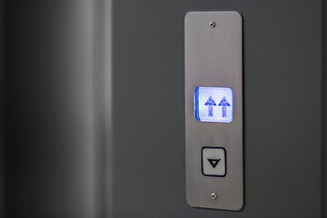 Metal panel with an elevator call button and an indicator of the direction of movement of the...