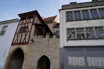 Fototapeta na wymiar Half timbered historic building and beside it a contemporary one in Altkirch France. The modern building has broken windows. Photo is taken in low angle view and shows contrast of two building style