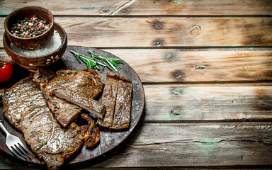 Grilled beef steaks with spices and rosemary.