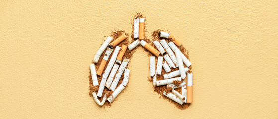 Lungs made of cigarettes and tobacco on beige background