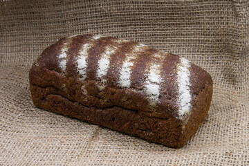 Black bread on a linen cloth. Bread sprinkled with flax and sunflower seeds.