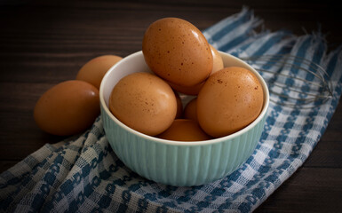 Fresh eggs in a bowl on a dark background