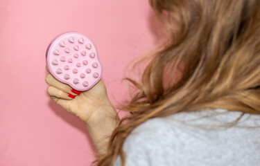 blonde hair girl woman holding ponytail up or silicone soft shampoo brush with bristles isolated on...
