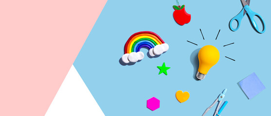 Idea light bulb with a rainbow and school supplies - flat lay