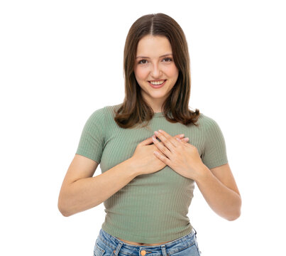 Charming young caucasian woman with lovely sincere smile feeling thankful and grateful, showing her heart filled with love and gratitude holding hands on her breast. Isolated on white background.