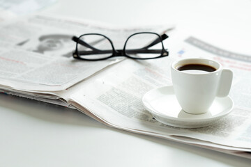 newspaper and eyeglasses on office desk