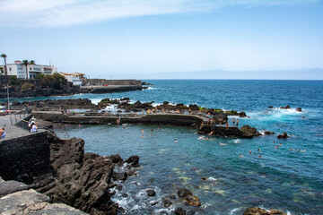 Fototapeta na wymiar Bay in the city of Puerto de la Cruz with lava stones in the sea