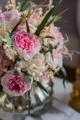 Bouquet with roses, hydrangea. Stabilized flowers in a white ceramic vase at home on the dressing table. Interior decor.