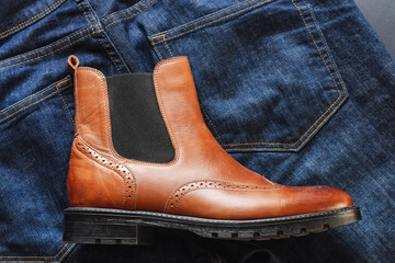Top view of light tan chelsea men boot with dark blue jeans. Fashionable men casual outlook.