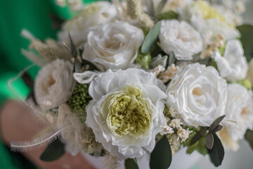 Girl in green jacket holding in her hands a of tender white flowers. Bouquet flowers a girl for mother's day, valentine's day, Woman's day 8 march