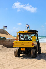 Fototapeta na wymiar Lifeguard car with flag of Israel at sea resort