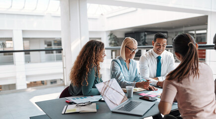Smiling businesspeople working at a table during a meeting