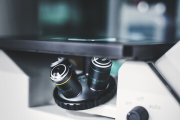 Closeup of the inverted microscope, microscopy with metal lens for bioassay in the laboratory. Research for pharmaceutical, medicine, and biotechnology development in the lab.