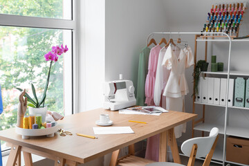 Tailor's workplace with sewing machine and supplies near window