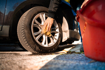 Close up of hand detailed cleaning brush rim wheels. The brush washes the car wheel with soap. Rubs...