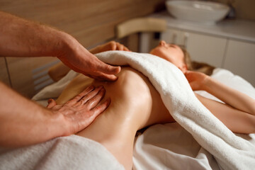 Obraz na płótnie Canvas Stomach acupressure massage. Male therapist massaging female abdomen