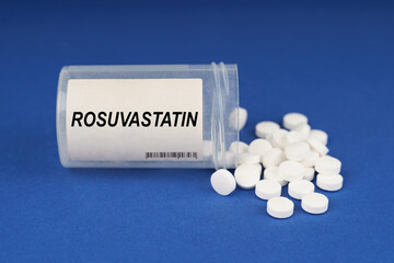 On a blue surface are pills and a dusty jar with the inscription - Rosuvastatin