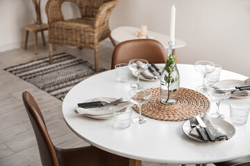 Beautiful table setting with candle in light room