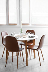 Beautiful table setting with candle in light room