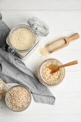 Jars with cereals on light wooden background