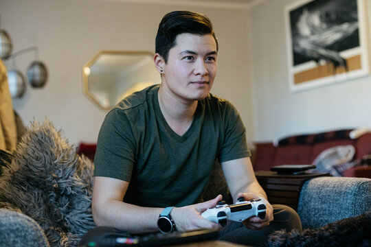 Transgender man plays video game at home 