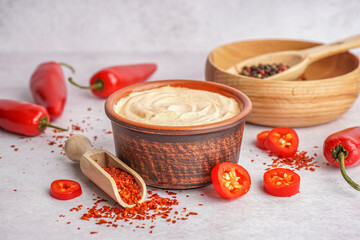 Bowl of tasty chipotle sauce and spices on light background