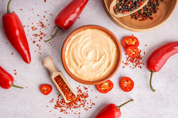 Bowl of tasty chipotle sauce and spices on light background