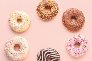 Frame made of different donuts on pink background