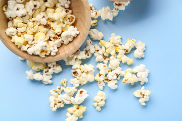 Obraz na płótnie Canvas Wooden bowl of tasty popcorn on color background, closeup