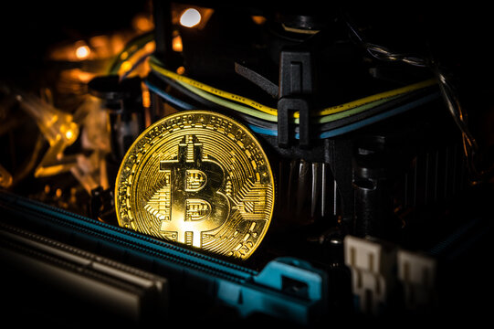 una moneda de bitcoin sobre una placa base y luces 