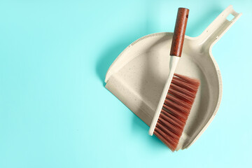Cleaning brush and dustpan on color background
