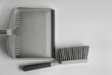 Dustpan and cleaning brush on light background