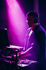 Music dj playing on stage in night club