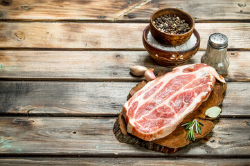 Raw pork steak with spices .