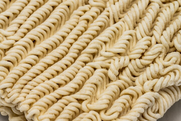 Dry instant ramen noodles on white background.