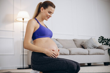 Pregnant woman hugging her belly with hands