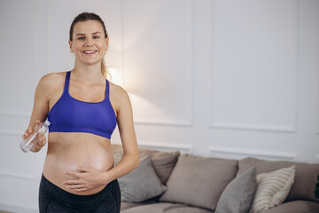 Naklejka na ściany i meble Pregnant woman using stretch mark oil