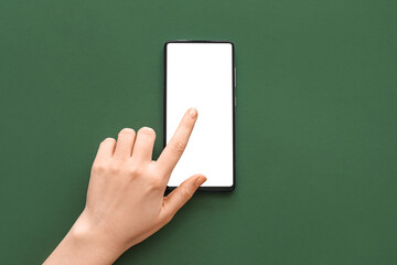 Female hand with modern mobile phone on green background, closeup