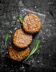 Cutlets on a black stone Board with rosemary.