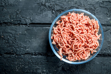Raw minced meat in a glass bowl .