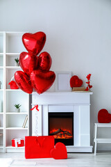 Interior of living room decorated for Valentine's Day with balloons, fireplace and gifts