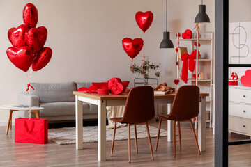 Interior of dining room decorated for Valentine's Day with table, sofa and balloons