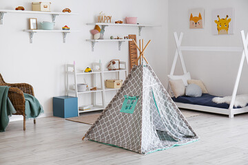 Fototapeta na wymiar Stylish interior of children's room with baby bed and play tent