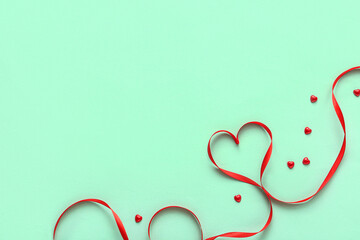 Red ribbon with hearts on green background. Valentine's Day celebration