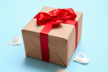Obraz premium Gift box tied with red ribbon on color background. Valentine's Day celebration