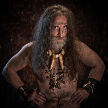 Primitive man with a beard in a cave