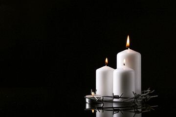Burning candles and barbed wire on dark background with space for text. International Holocaust...