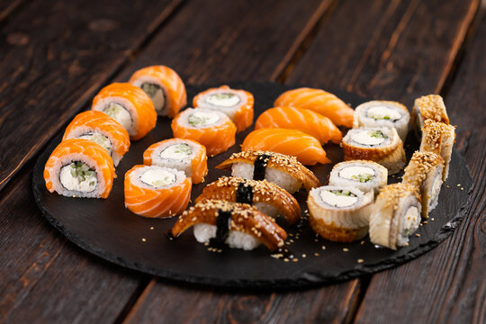 Sushi set from top on black background. An assortment of various maki nigiri and rolls seafood soy sauce