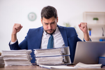 Young male employee and too much work in the office