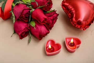Beautiful burning candles, rose flowers and balloon on color background, closeup. Valentine's Day celebration